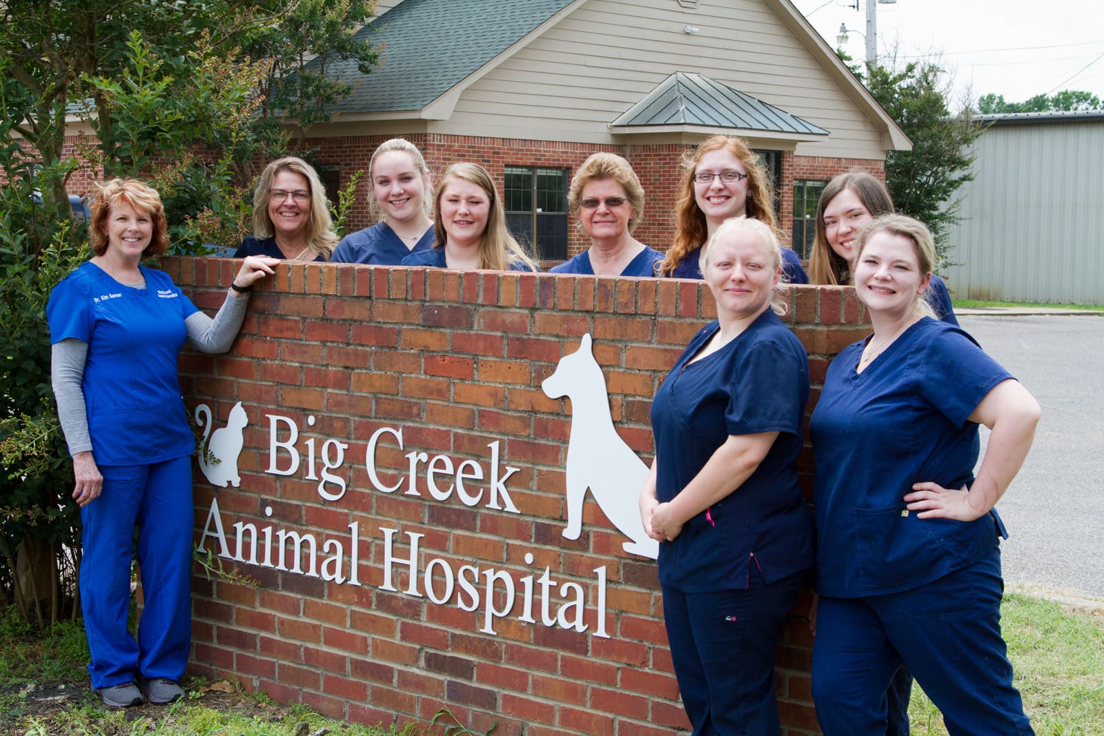 Big Creek Animal Hospital staff standing near the hospital's sign